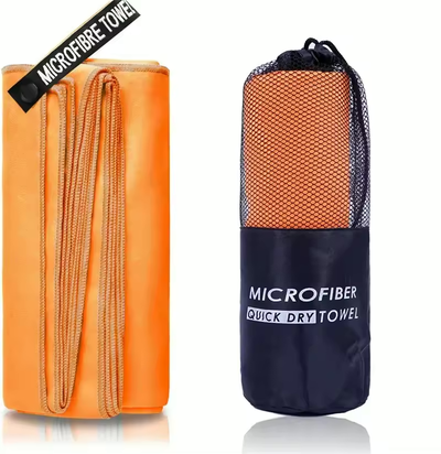 Oransje mikrofiberhåndkle sammenbrettet ved siden av oppbevaringspose i mesh
